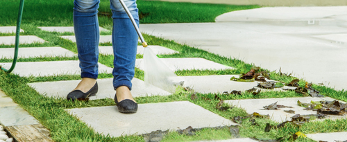 Woman using Power Jet in cleaning the lawn steps